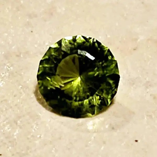 Gleaming Green: 1.25ct Round Facetted Peridot - Scandinavian Gem Design