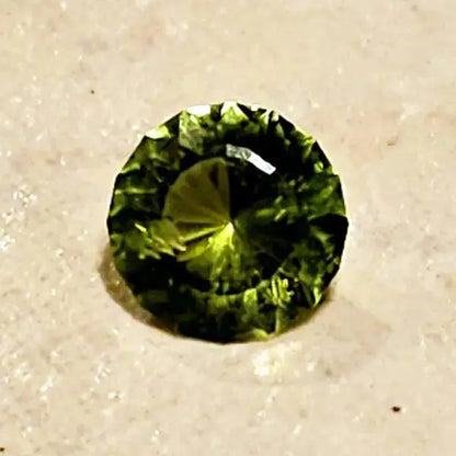 Gleaming Green: 1.25ct Round Facetted Peridot - Scandinavian Gem Design