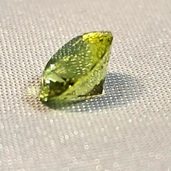 Gleaming Green: 1.25ct Round Facetted Peridot - Scandinavian Gem Design