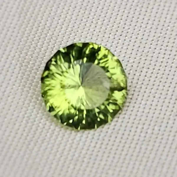 Gleaming Green: 1.25ct Round Facetted Peridot - Scandinavian Gem Design